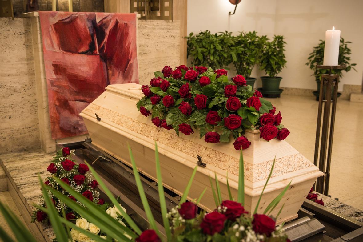 Aufgebahrter Sarg mit Blumenschmuck aus roten Rosen