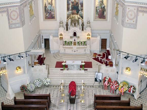 Mit roten Blumen geschmückter Sarg in Kapelle